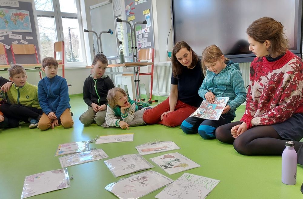 Paní učitelka se s pochopením sklání k chlapci a dívce ve třídě