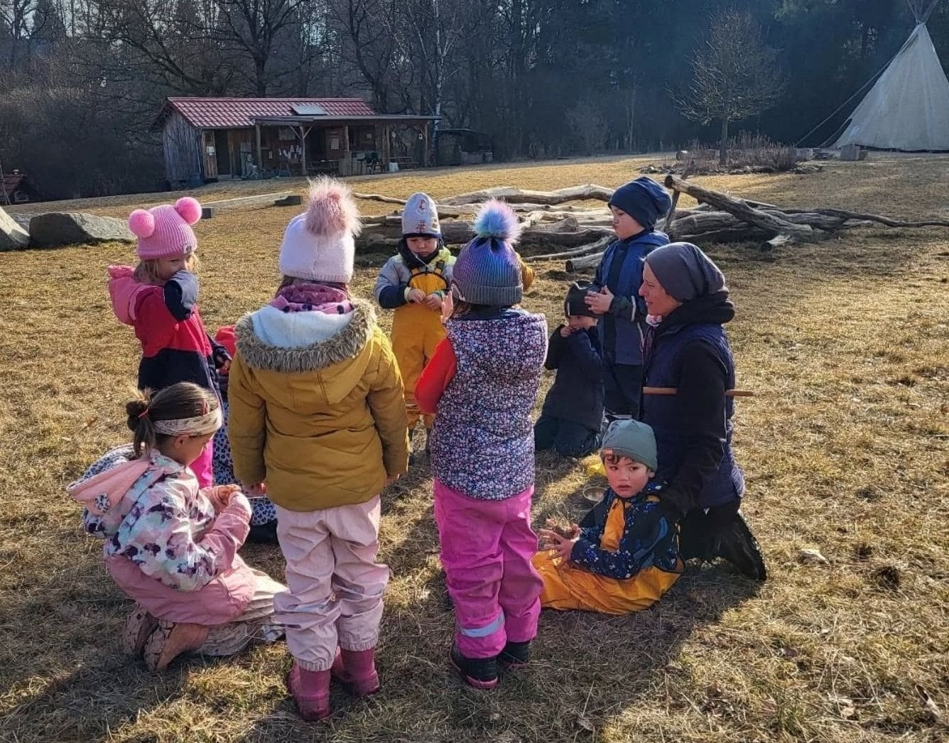 Děti si společně hrají na zahradě lesní mateřské školy Devětsil