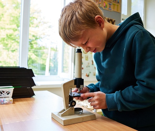 Dívka s mikroskopem při skupinové práci